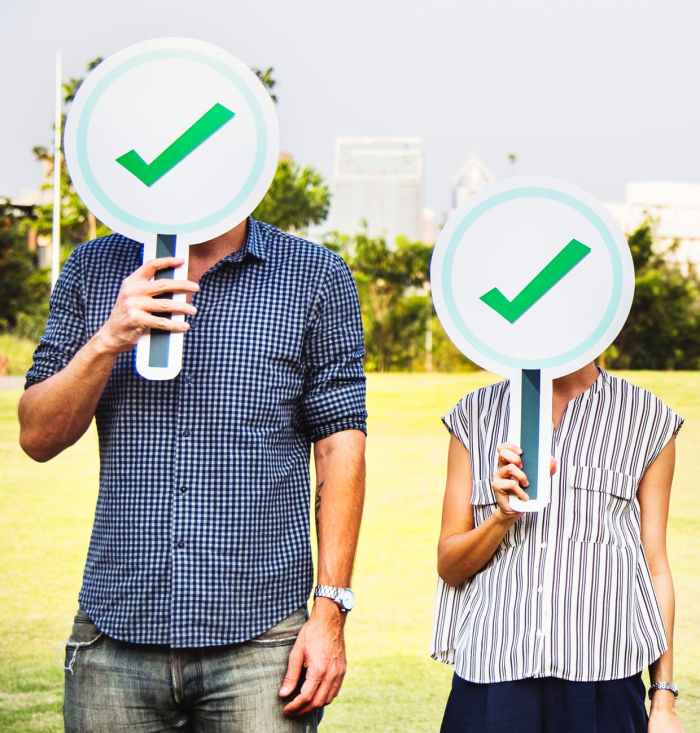 man and woman holding check signage